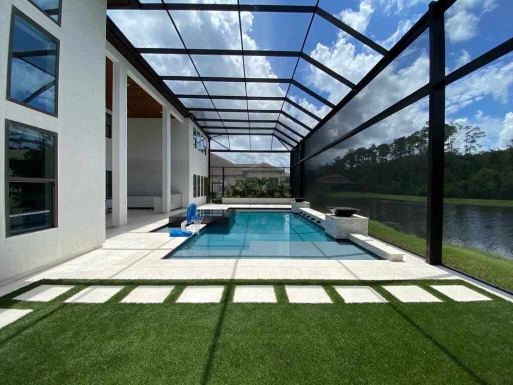 Modern pool screen enclosure installation in Titusville, FL overlooking waterfront backyard